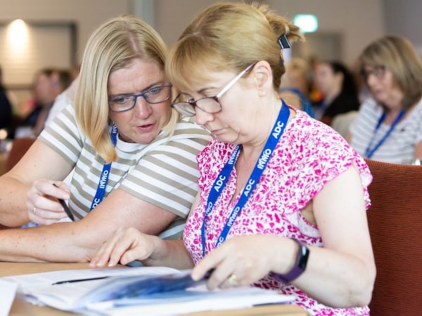 two nurses taking notes and chatting at adc 2025